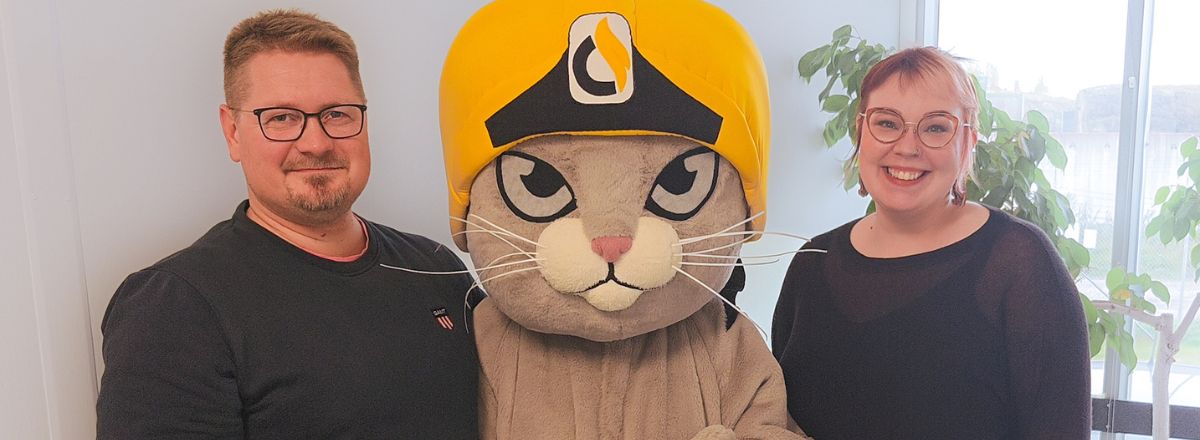 Kuvassa HÄLY-suurleirin leirinjohtaja Mikko Rauhanen, Maskotti Häly-kissa ja leirin projektipäällikkö Sari Lehtonen.